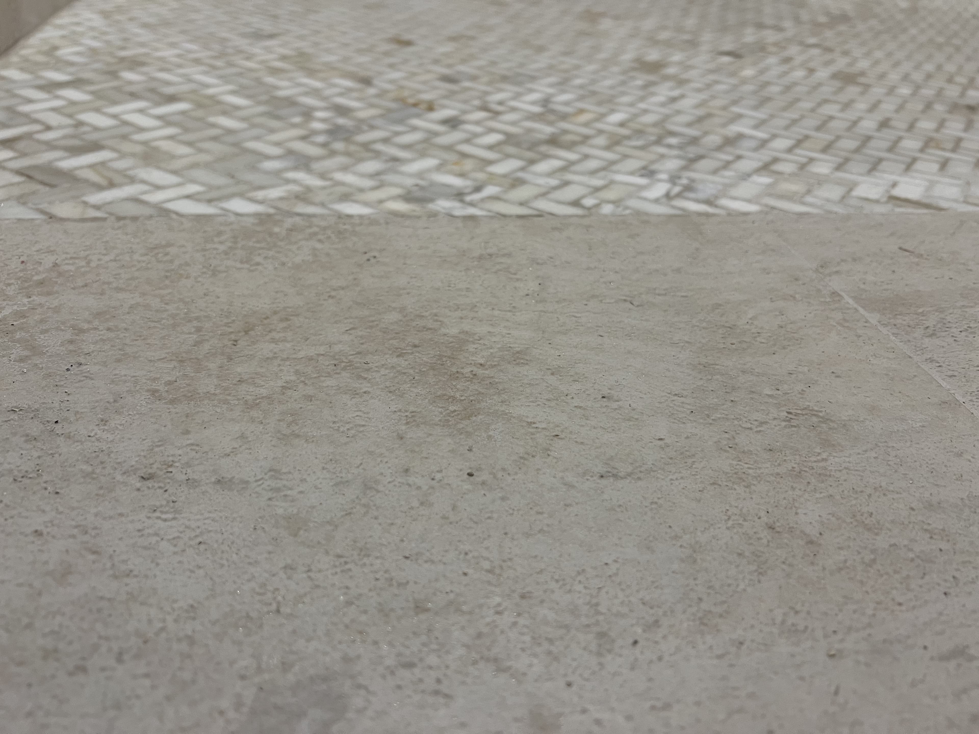 Tile flooring transition with herringbone mosaic